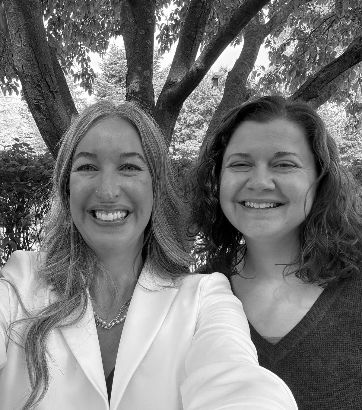 Amanda Porter and Kaylee Tanner smiling together under a tree