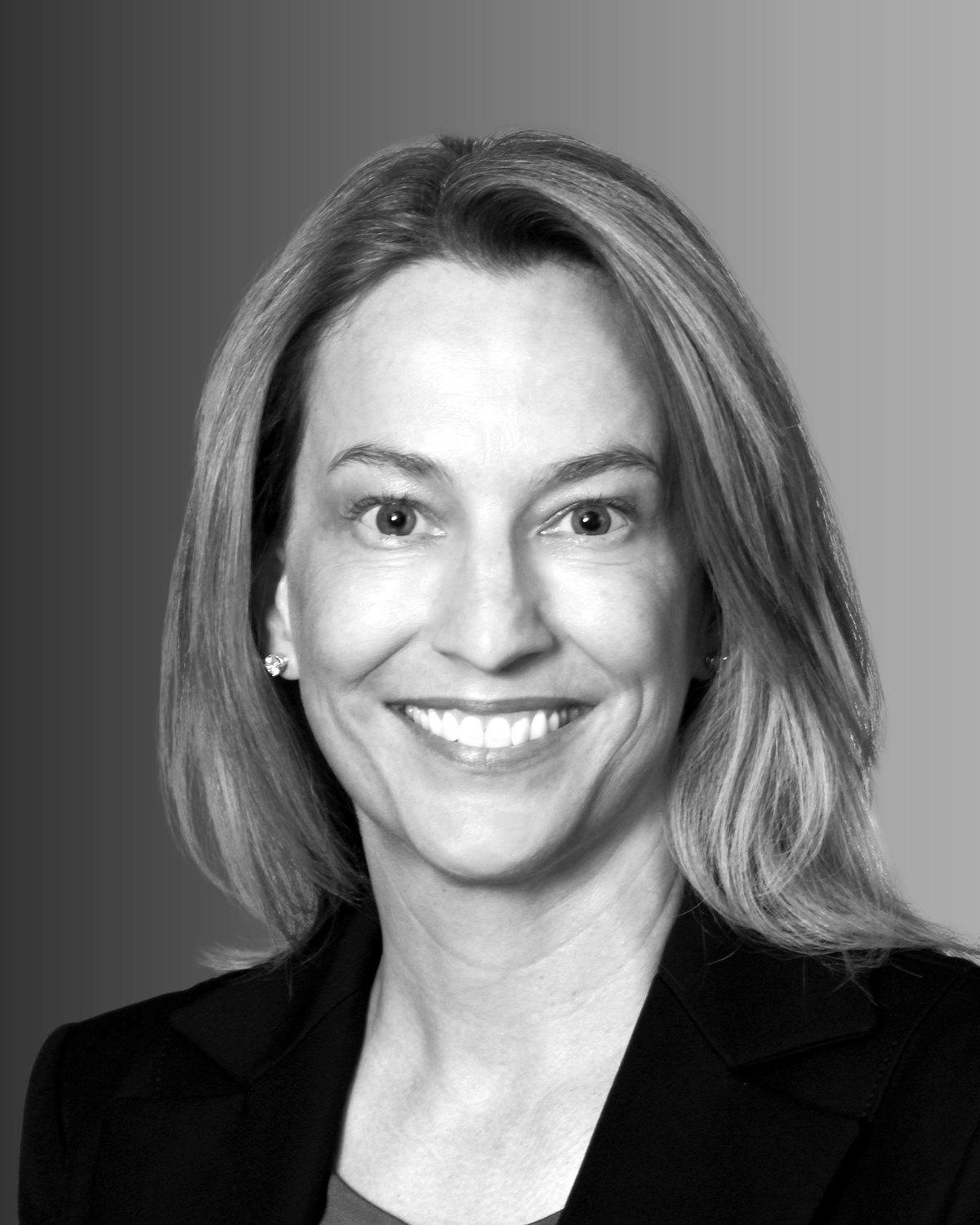 Dr. Maggie Koos, founder of Koos Medical Innovations, smiling in a dark blazer